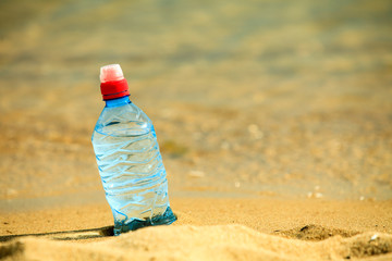 bevarage. bottle of water drink on a sandy beach.