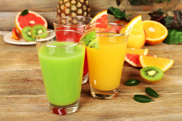 Fresh juices with fruits on wooden table