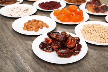 Different products on saucers on wooden table, closeup