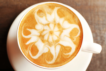 Cup of coffee latte art on wooden table, closeup