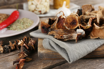 Dried mushrooms with spices on wooden background