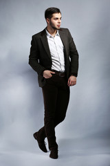Elegant man in suit on gray background