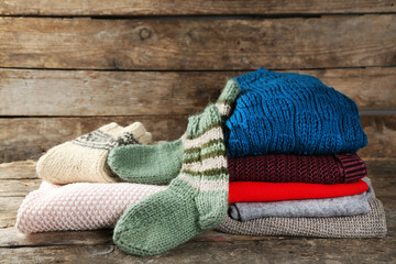 Knitting clothes on wooden background