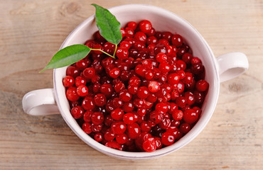 Red currant in bowl on wooden table, closeup