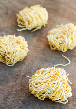 Fresh pasta nests on wooden table