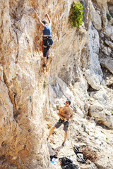 Senior woman lead climbing, guy belayer watching her