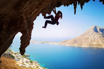 Fototapeten Female rock climber struggling on challenging route on cliff  © Andrey Bandurenko