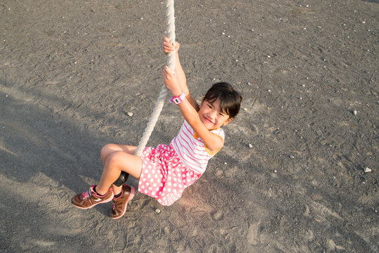 公園のターザンロープで遊ぶ女の子