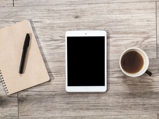 White Tablet with blank black screen on the wooden background