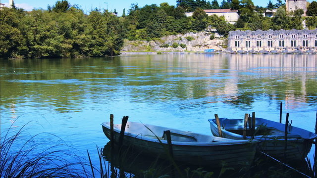 Small ferry crossing the blue water of Adda river