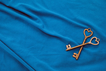Two vintage keys on blue fabric