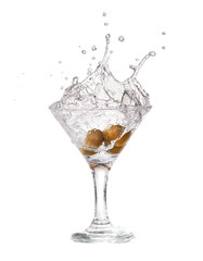 Splash from olive in a glass of cocktail.