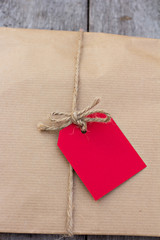 gift in kraft paper with red card  on a wooden table
