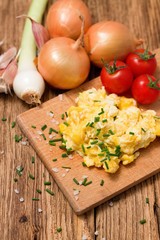 Vertical photo of scrambled eggs on chopping board