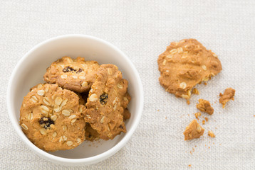 Cookies, cereals in white bowl With debris on the table.