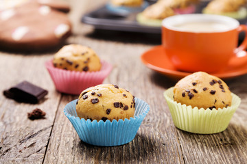 muffins with chocolate in colorful tins served with a cup of cof
