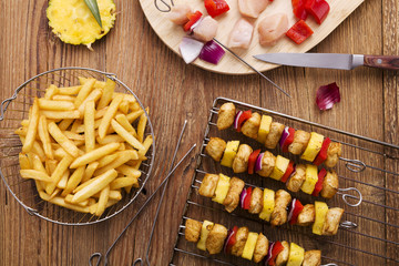 Grilled chicken skewers with pineapple, peppers and onions serve