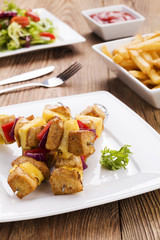 Grilled chicken skewers with pineapple, peppers and onions serve