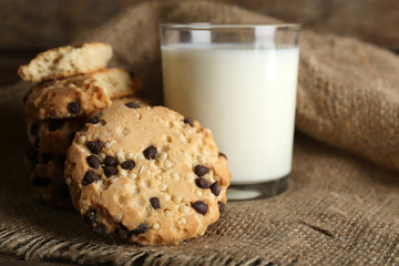 Tasty cookies and glass of milk on rustic wooden background