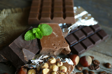 Set of chocolate with nuts on wooden table, closeup