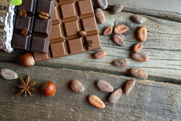 Delicious chocolate with spices on wooden table, closeup