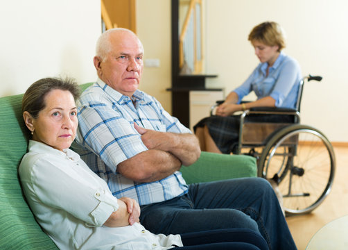 Mature couple and disabled woman indoor