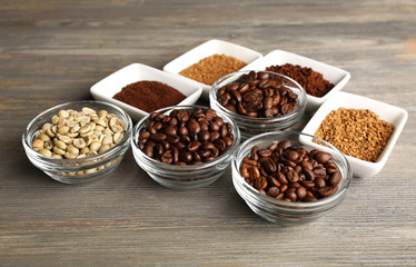 Coffee beans in saucers on wooden background