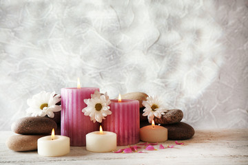 Still life with spa candles on light wallpaper background