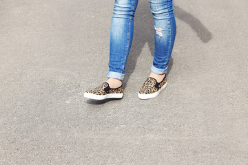 Female feet over gray asphalt background