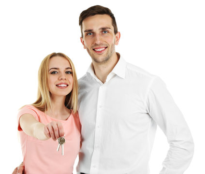 Attractive young couple showing new house key, isolated on white