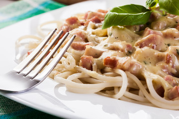 Spaghetti carbonara with bacon and basil