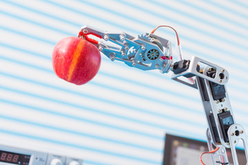 red apple in a  robot  arm