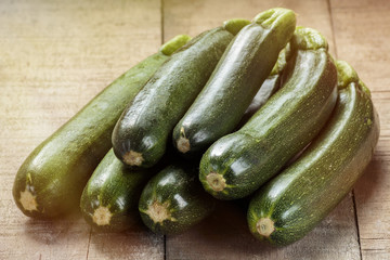 Green zucchini on wooden table, processed with sun glow effect