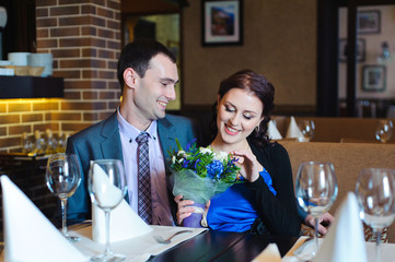 Young attractive couple enjoying sitting together in a restauran