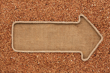 Pointer made from rope with grain buckwheat  lying on sackcloth