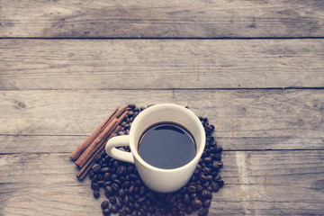 Coffee cup and coffee beans on old wooden background
