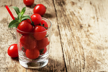 Funny cool tomato juice and tomatoes in a glass, selective focus