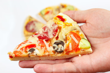 Hand with a piece of tasty pizza close up