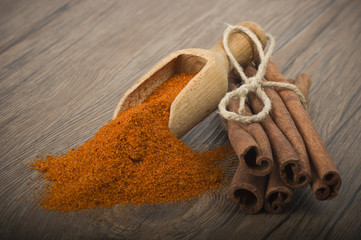 cinnamon sticks with powder on the wood table