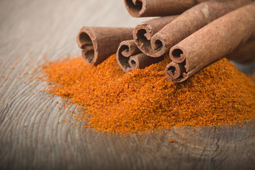 cinnamon sticks with powder on the wood table