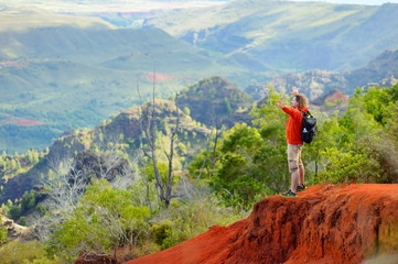 Obraz premium Young man enjoying a view into Waimea Canyon