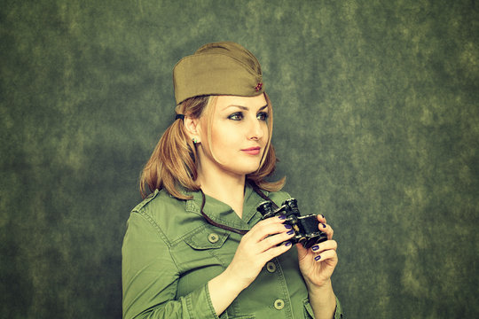 The girl in military clothes, in his cap, with binoculars