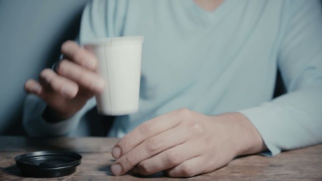 Young man drinking tea from a paper cup