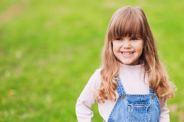 Cute little girl on the meadow in summer day