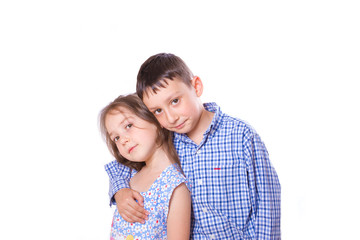 Brother sister hugging kcherz shoulder and smiling together on white background