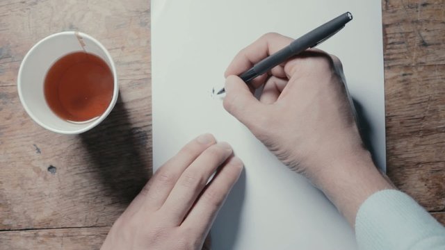 Man drinking tea and trying to write a letter
