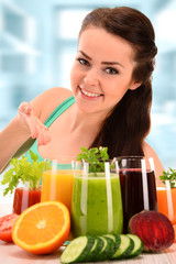 Fototapeta premium Young woman with variety of vegetable and fruit juices