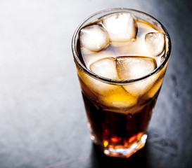 cola with ice on a wooden background. soft drinks