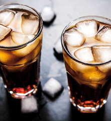 cola with ice on a wooden background. soft drinks