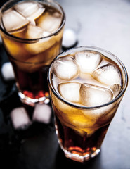 cola with ice on a wooden background. soft drinks